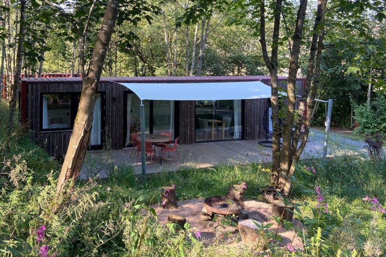 CABIN SÜD Modernes Seecontainer Tiny House im Grünen mit Terrasse und Überdachung.